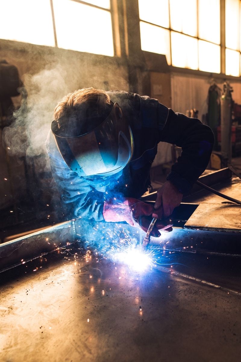 image of person welding metal pieces together on a table in a shop
