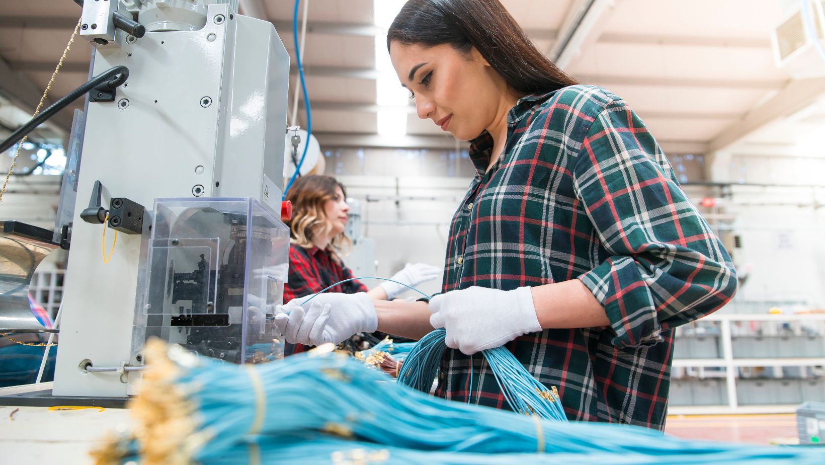 millennial hispanic woman working inside an electronics manufacturing plant